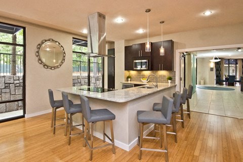 a large kitchen with a bar and chairs